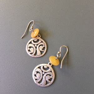 Round silver earring with yellow gemstone